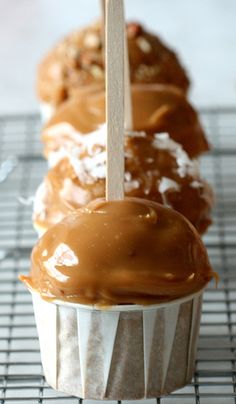 three cupcakes with caramel frosting on a cooling rack