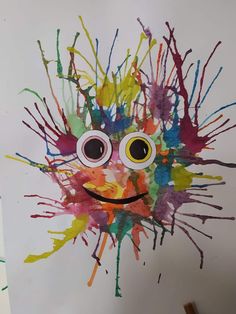 a child's art project with paint splattered on the face and eyes