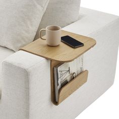 a coffee table with magazines and a cell phone on it in front of a couch