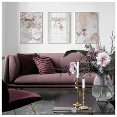 a living room filled with furniture and flowers on top of a coffee table in front of a window