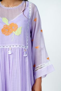 Lavender kota doriya tunic with floral applique and lace work. Comes with matching an inner.
Component: 2
Pattern: Woven, Embroidered
Type Of Work: Applique
Neckline: Round
Sleeve Type: Sheer
Fabric: Kota Doriya
Color: Purple
Other Details: 
Floral applique motifs
Lace detail
Fabric tassels
Pleated detail
Tunic length 38 inch
Occasion: Resort - Aza Fashions Summer Chanderi Kurta With Floral Embroidery, Purple Chikankari Embroidery Sets For Summer, Purple Chikankari Embroidered Sets For Summer, Summer Purple Sets With Chikankari Embroidery, Spring Cotton Dresses With Cutwork, Spring Chanderi Dress With Floral Embroidery, Spring Embroidered Chanderi Dress With Floral Embroidery, Summer Cotton Silk Sets With Floral Embroidery, Spring Floral Embroidery Mulmul Sets