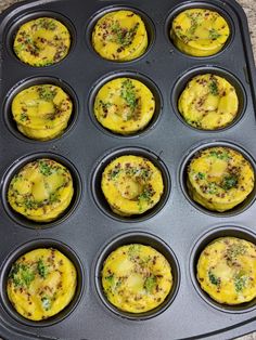 muffins in a black pan with yellow toppings and sprinkles