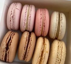 a box filled with different colored macaroons sitting next to each other