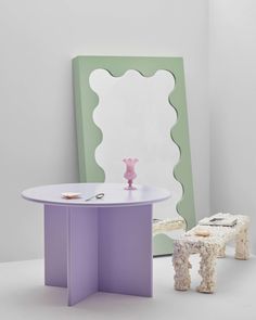 a table with two stools and a mirror in the back ground, next to each other