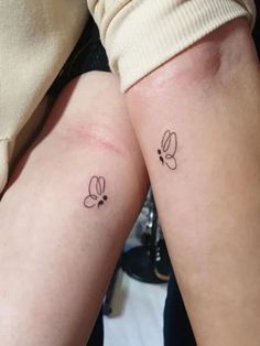 two people with matching tattoos on their legs, one has a small butterfly tattoo on the other