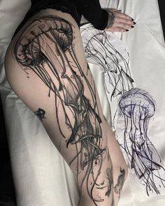 a woman laying on top of a bed next to a jellyfish tattoo design in black ink