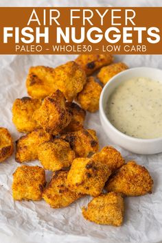 fried tater tots with dipping sauce on white paper next to small bowl full of ranch dressing