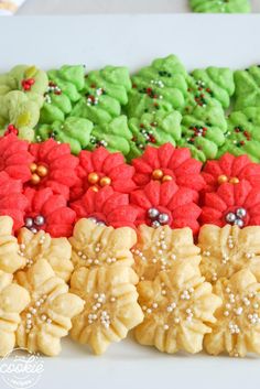 there are many decorated cookies on the plate and one is green, red, and yellow