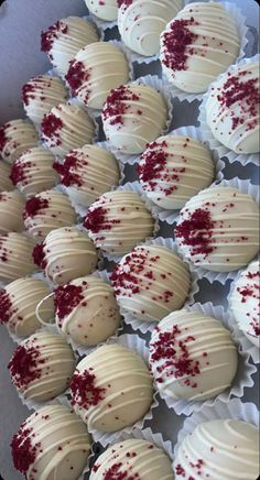 white chocolates with red sprinkles on them in paper wrappers lined up