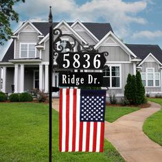 a house with a flag on the lawn and a sign for ridge dr in front