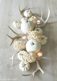 a table topped with antlers, candles and flowers