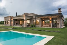 a house with a pool in front of it and a covered patio next to it