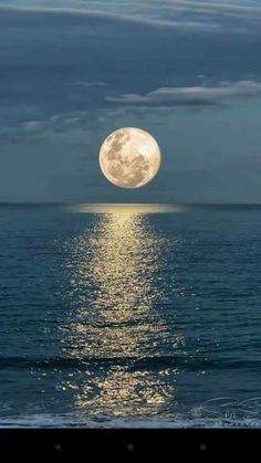 the full moon is shining over the ocean and it's reflection in the water