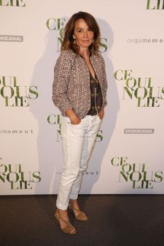 a woman standing on top of a carpet next to a white wall with green lettering