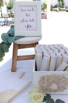 a table topped with lots of cards next to a wooden box filled with paper fans