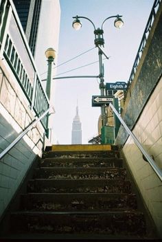 stairs leading up to the top of a building with a view of empire state building in the background