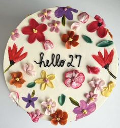 a cake decorated with flowers and the words hello 2 1 on it's side