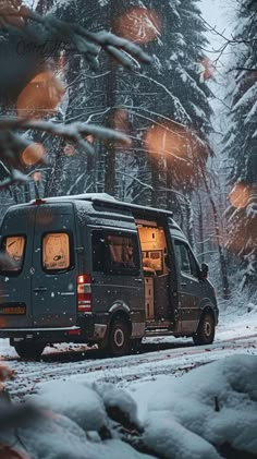 a van parked on the side of a snow covered road in front of some trees