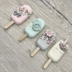 four different colored toothbrushes with bows and flowers on them sitting on a wooden surface