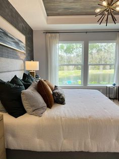 a bedroom with a large bed and a chandelier hanging from it's ceiling