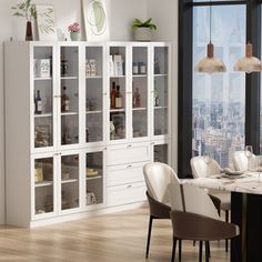 the dining room table is set with white chairs and an open bookcase in front of a large window