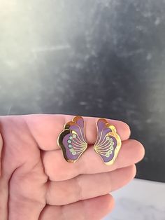 These are a vintage pair of Laurel Burch peony stud earrings.  Hallmarks: Laurel Burch  Weighs: 5 grams  .75" tall and 1 1/16" wide  All measurements are approximate.  Condition: Good vintage condition. Normal wear associated age. A few light surface scratches and slight discoloration. Please see photos. Sold as is. Priced accordingly.  Please look over carefully and inspect any and all photos. Our shop is committed to fully disclosing all items' conditions and history with as great of detail as Purple Clip-on Jewelry As Gift, Purple Clip-on Jewelry As A Gift, Purple Clip-on Jewelry Gift, Purple Clip-on Jewelry For Gift, Purple Clip-on Jewelry For Gifts, Lavender Flower-shaped Earrings For Gifts, Laurel Burch Horses, Tory Burch Stud Earrings, Vintage Purple Flower Earrings