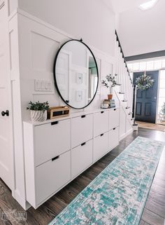 a room with white cabinets and a blue rug on the floor in front of it