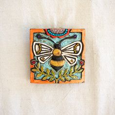 a ceramic wall hanging with a bee on it