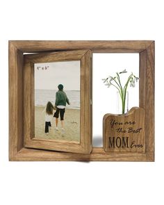 a wooden frame holds an image of a mother and her child on the beach with a flower in it