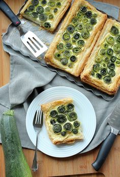 there are two pieces of bread with olives on it next to a knife and fork