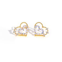 two heart shaped earrings with blue and white stones on the front, in gold tone