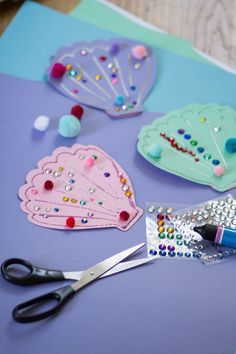 craft supplies laid out on a table with scissors and other things to make them look like they are made from paper