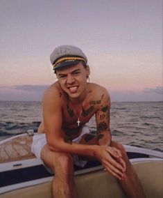 a man sitting on the back of a boat in the ocean with his arm crossed