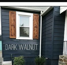 there is a blue house with shutters on the front and side windows that say dark walnut