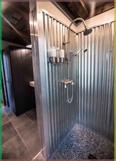 a walk in shower sitting inside of a bathroom next to a tiled floor and walls