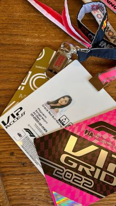 several lanyards are laid out on a wooden table with ribbons and tags attached to them