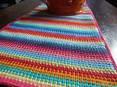 a crocheted table runner with a mug on it