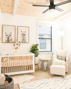 a baby's room with a crib, rocking chair and pictures on the wall