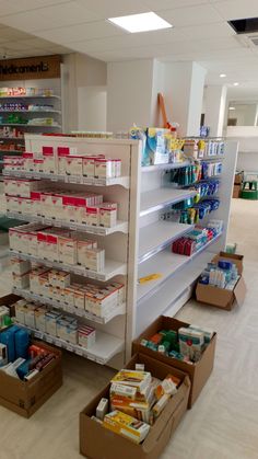 the shelves are full of food and supplies in this grocery store with boxes on the floor