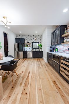 a kitchen with wood floors and black cabinets