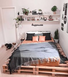 a bed made out of wooden pallets with pillows and blankets on top of it