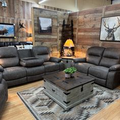 a living room with two couches, a coffee table and a deer head on the wall