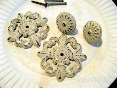 an assortment of decorative knobs and screws on a white plate with a screw in the middle