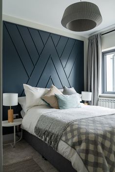 a bedroom with blue walls and white bedding is pictured in this image, there are two lamps on either side of the bed