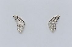 two silver earrings with leaves and dots on the bottom one has a small bead in the middle