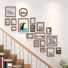 there are many pictures hanging on the wall next to the stair case and bookshelf