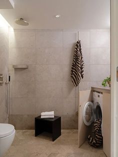 A modern bathroom with rectangular limestone tiles on the wall and a herringbone pattern on the floor and shower wall for a classic and elegant effect