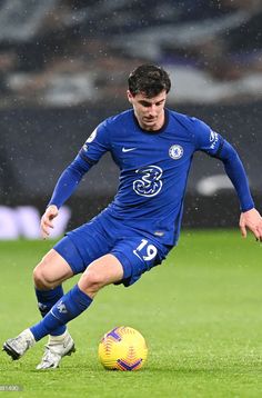 a soccer player in action on the field during a game with rain falling over him