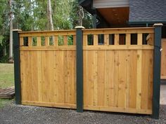 a wooden fence with green posts and bars on the top, in front of a house