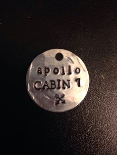 a metal tag that says cabin 1 and is hanging on a black leather surface with the word cabin 1 printed on it